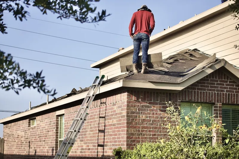 Professional roofer working on a residential roof in Crossroads